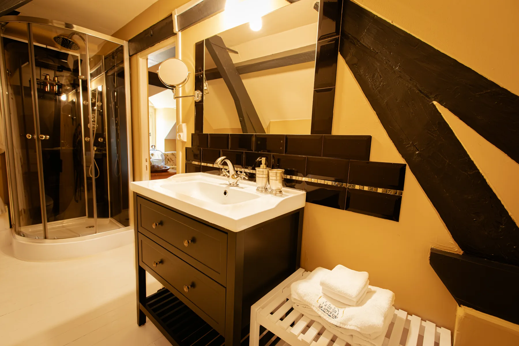 Badkamer met wastafel en douche van kamer Beau Merle bij La Joyeuse