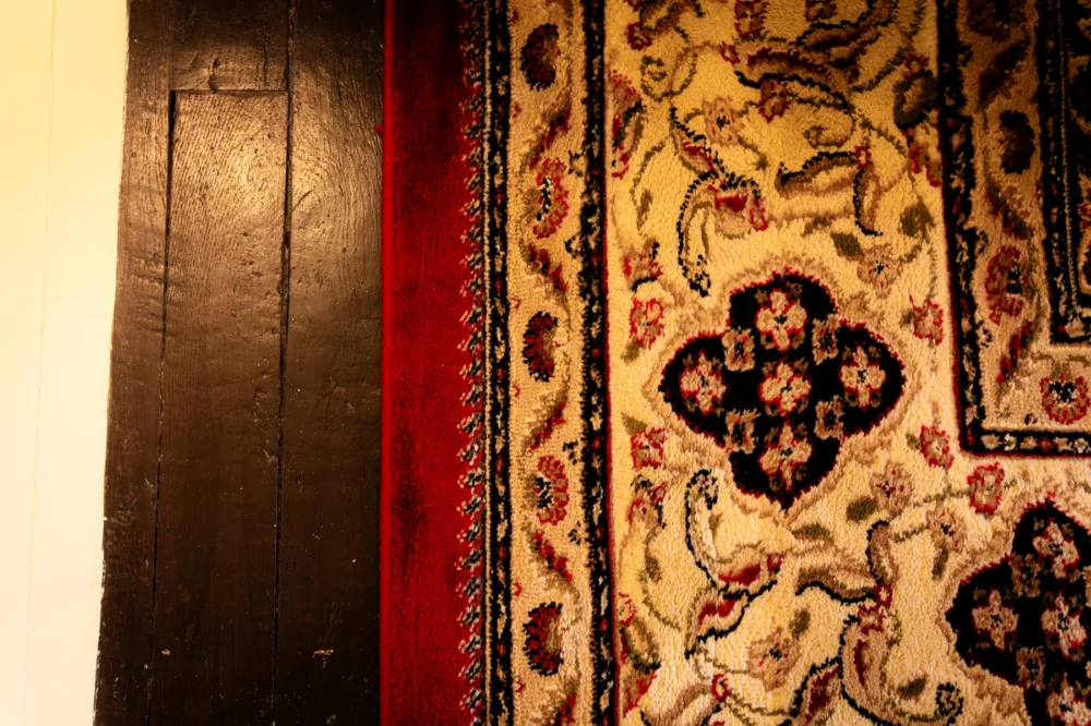 Detail van het tapijt en de inrichting in kamer Clos bij La Joyeuse
