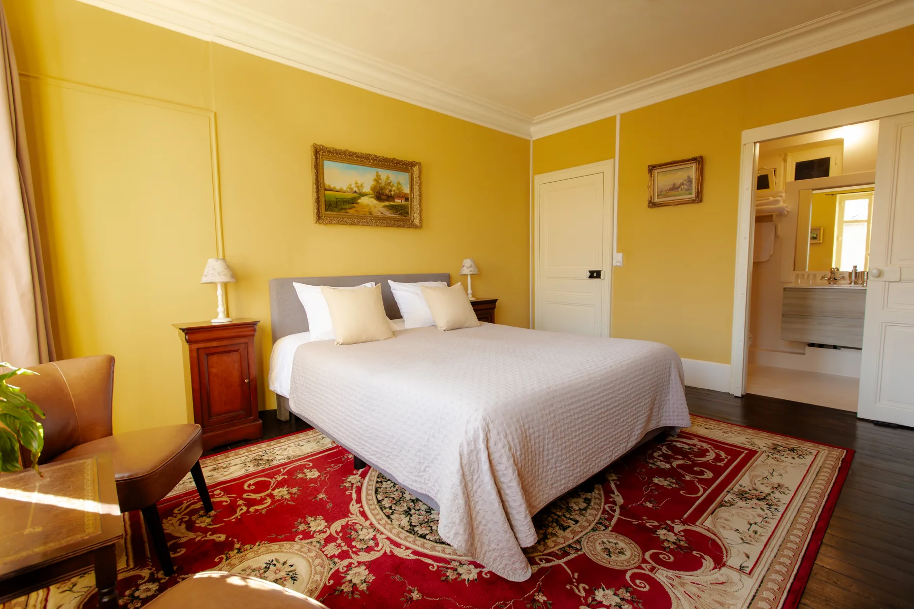 Kamer Reflet met bed en doorgang naar badkamer bij La Joyeuse
