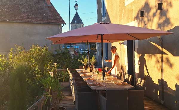 Grande table dressée sur la terrasse de La Joyeuse au soleil du soir