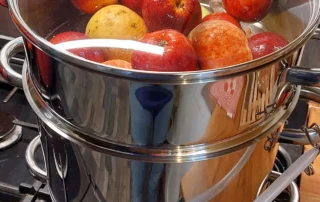 Pommes du verger de La Joyeuse dans un extracteur de jus à vapeur